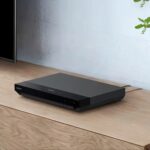 Sony UBP‑X700/K 4K Blu‑ray player placed on a dark table with a disc visible